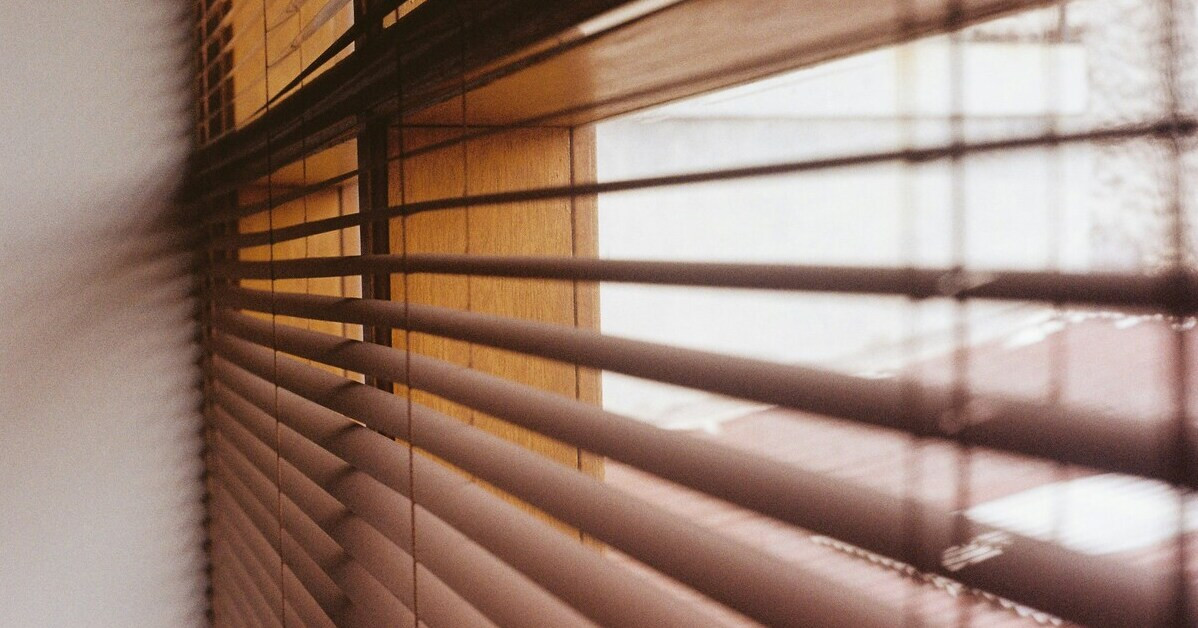 Jalousien an einem Fenster aus Holz im Tageslicht