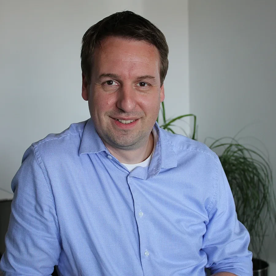 Marc Lorenz im Büro mit blauem Hemd
