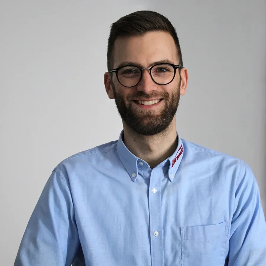 Tim Hakemeyer in einem hellblauen Hemd vor neutralem Hintergrund