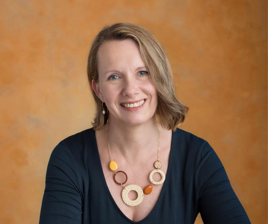 Porträtfoto von Heike Hahn vor orangem Hintergrund