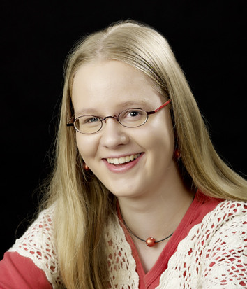 Porträtfoto von Inken Hagestedt mit langer blonder Haarpracht vor schwarzem Hintergrund
