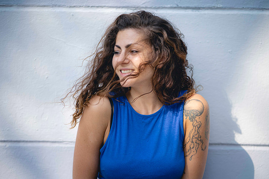 Porträt von Mousa Samira mit lockigen Haaren und Tattoo am Arm