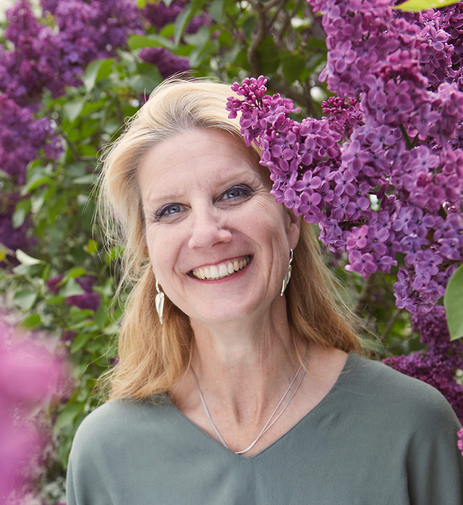 Britta Zytariuk vor blühendem Flieder im Garten