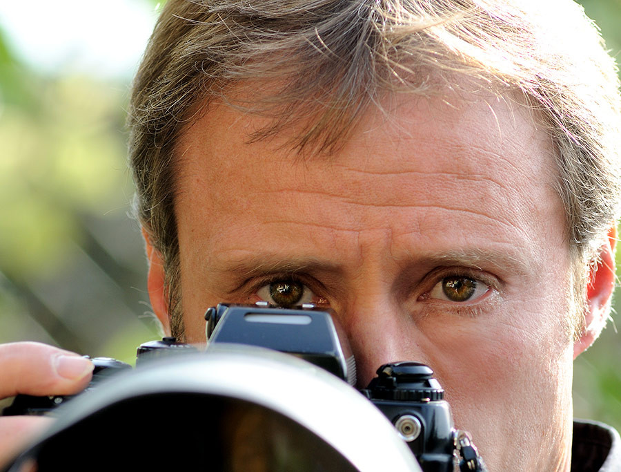 Kaiser Thomas fotografiert mit einer Kamera, Nahaufnahme von hinten
