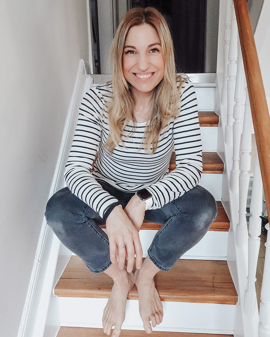 Julia Scharnowski sitzt entspannt auf einer Treppe in Freizeitkleidung