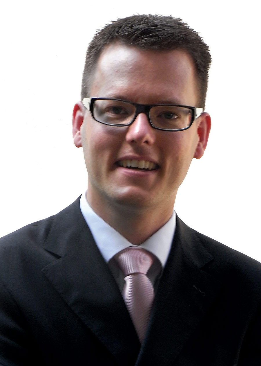 Porträt von Bien Ulrich im Anzug und mit Brille