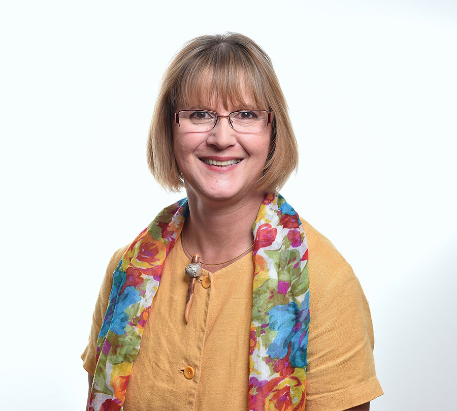 Portrait von Andrea Christiansen mit buntem Schal und gelber Bluse