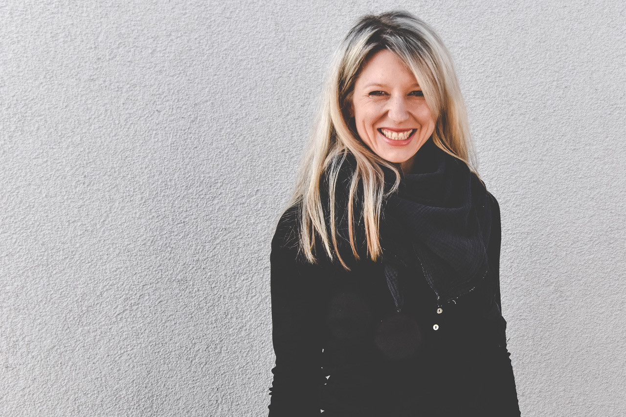 Porträt von Laura Fröhlich vor einer grauen Wand