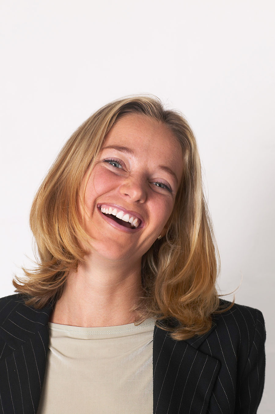 Porträtfoto von Katrin Hoefer, Frau mit blondem Haar im Business-Outfit vor hellem Hintergrund