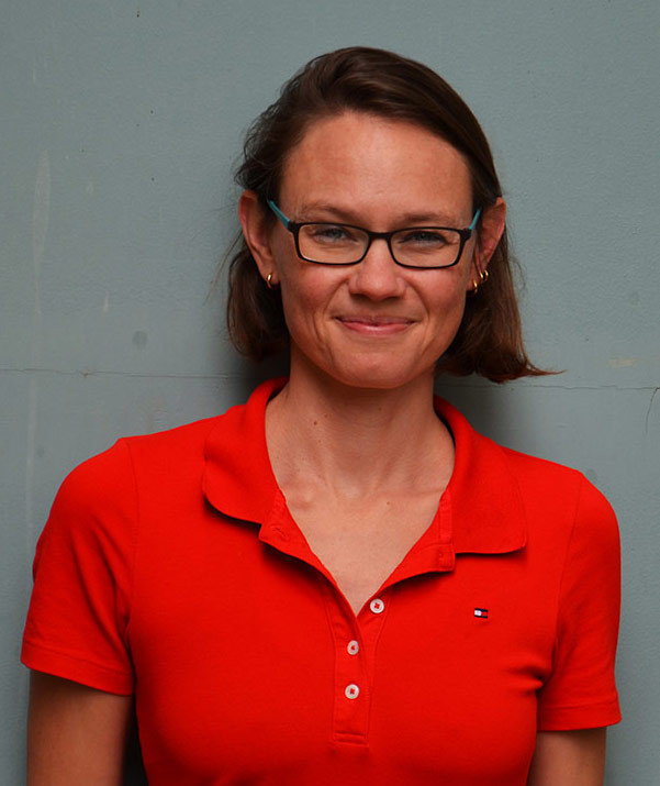 Portrait von Inke Hummel in rotem Poloshirt vor grauem Hintergrund