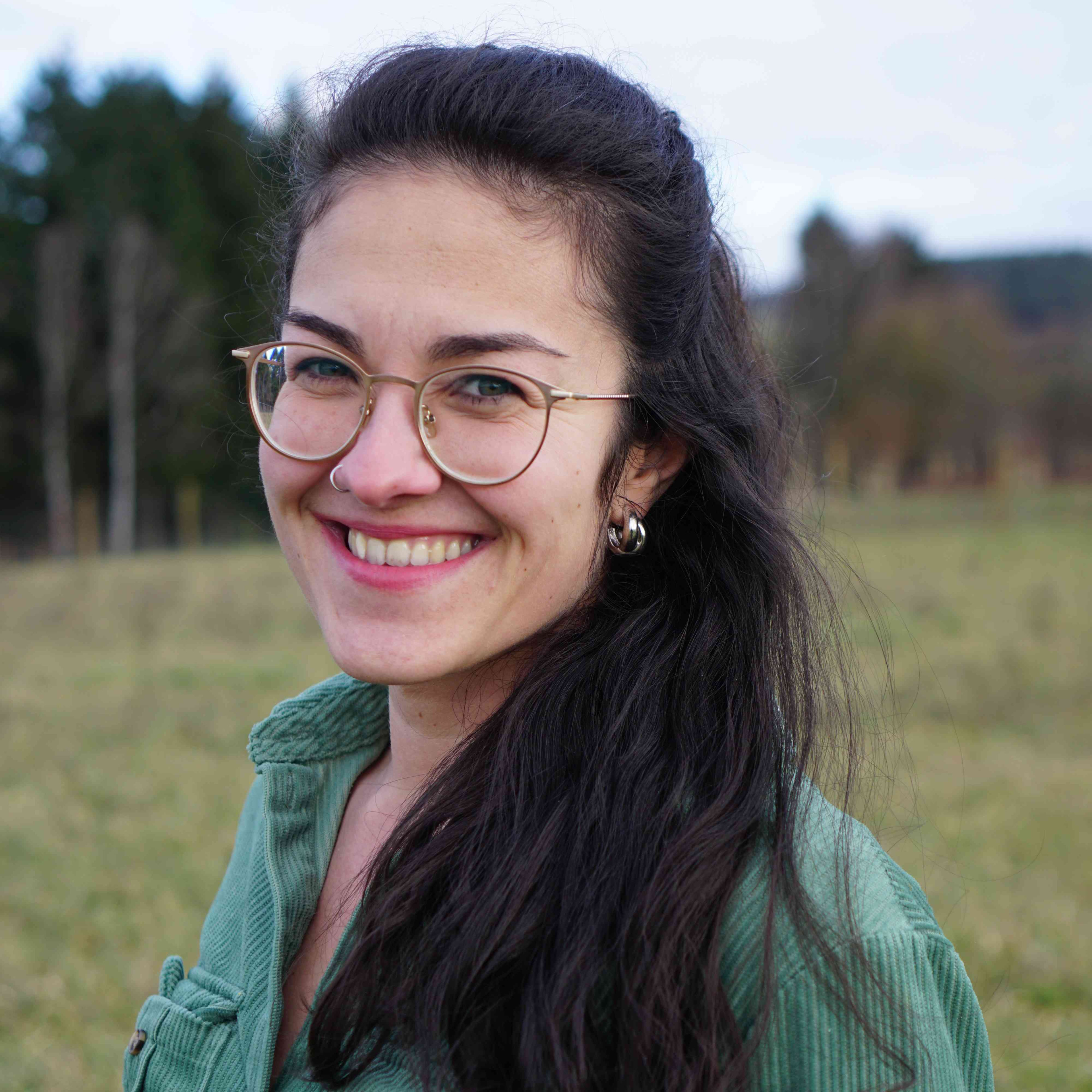 Porträt von Danijela Klich im Grünen, Frau mit langen dunklen Haaren und Brille