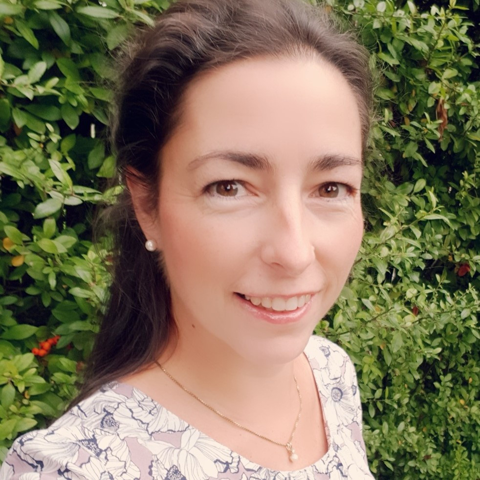 Porträt von Vivian Koenig im Garten mit Blumenmuster-Kleid