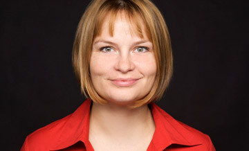 Portraitfoto von Karin Leppin mit rotem Hemd vor schwarzem Hintergrund