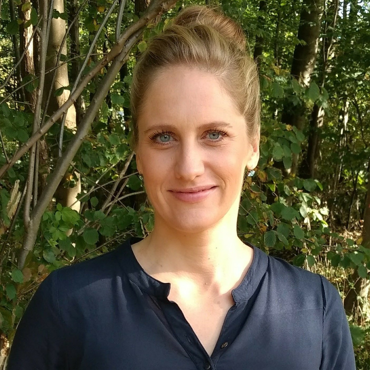 Porträtfoto von Dr. med. Ursula Manunzio im Freien vor Bäumen