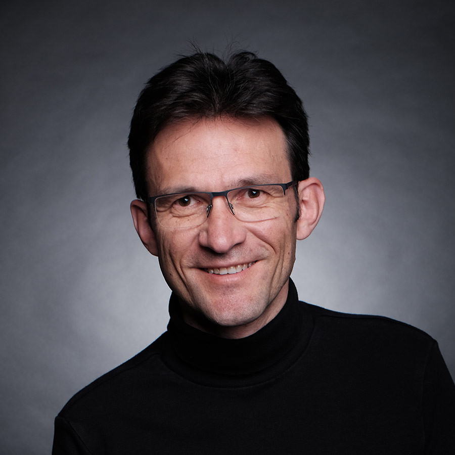 Portraitfoto von Peter Michalik vor dunklem Hintergrund