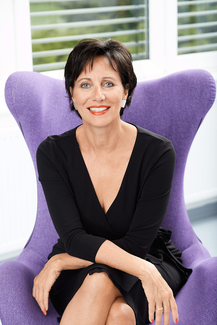 Portrait von Andrea Micus auf einem lila Sessel