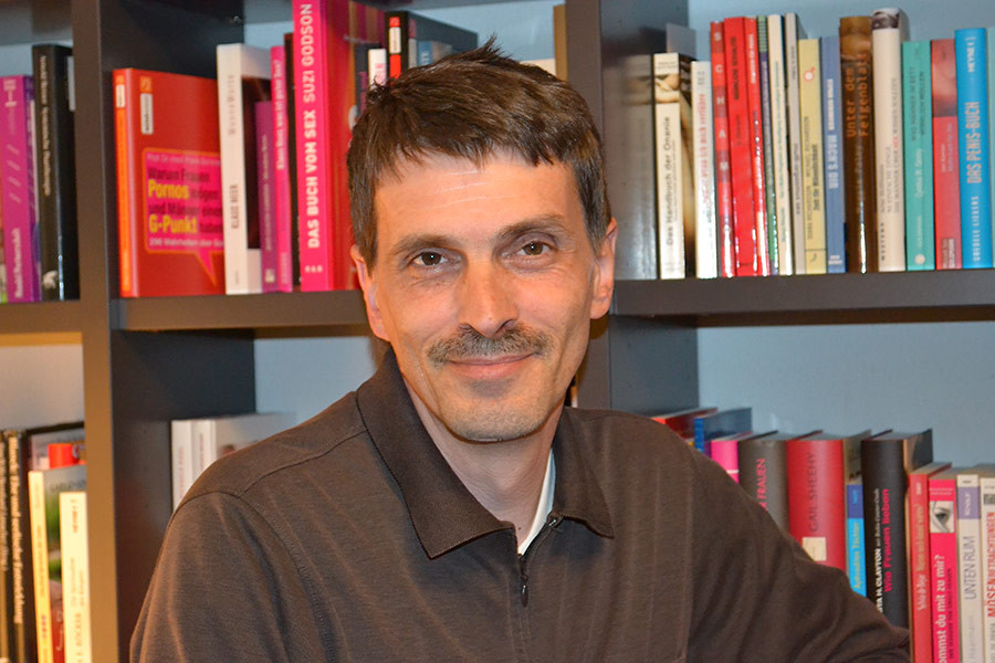 Moritz Bernhard vor einem Bücherregal