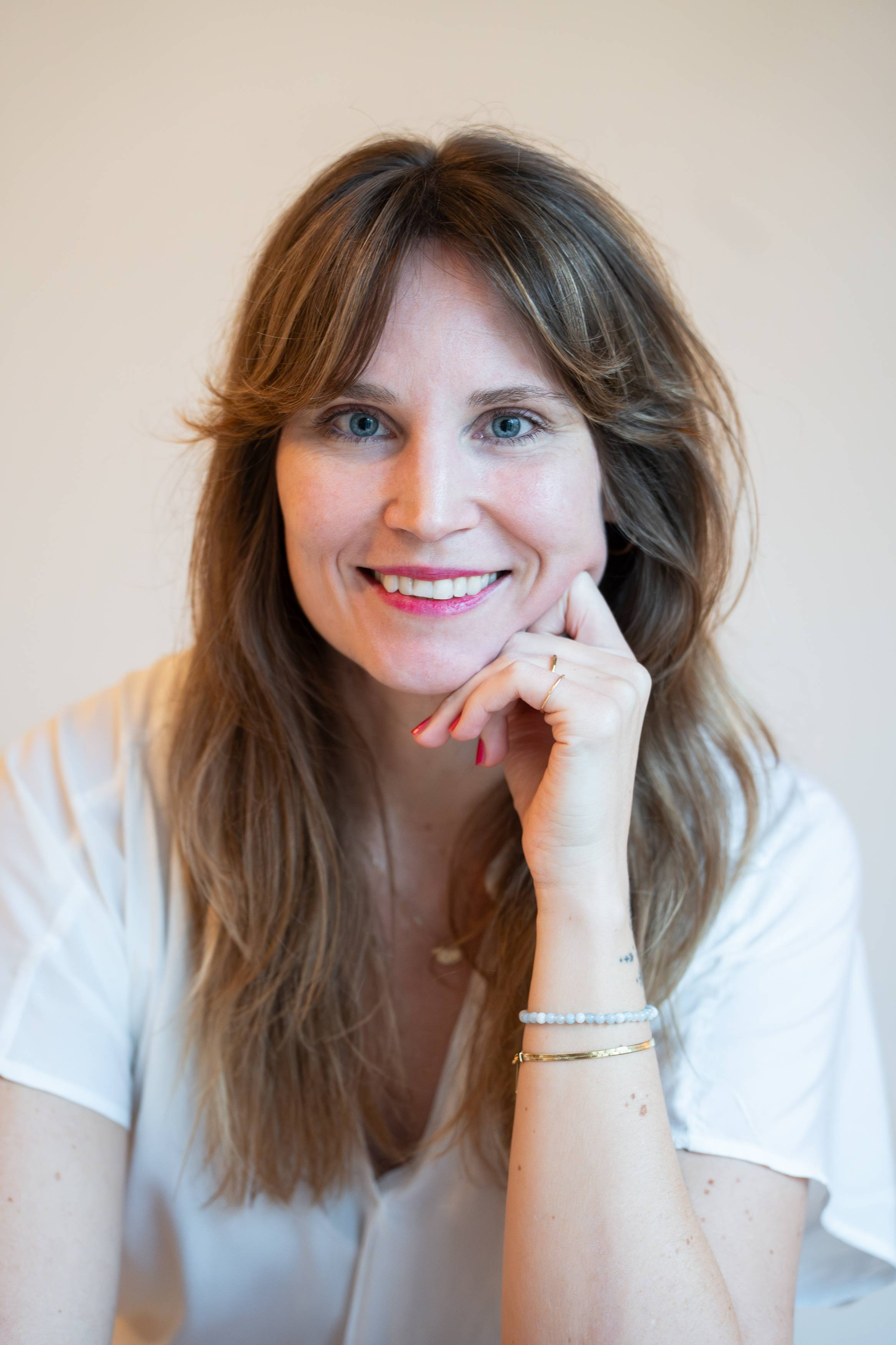 Porträtfoto von Isabelle Müller-Pal, Frau mit langen braunen Haaren und weißer Bluse