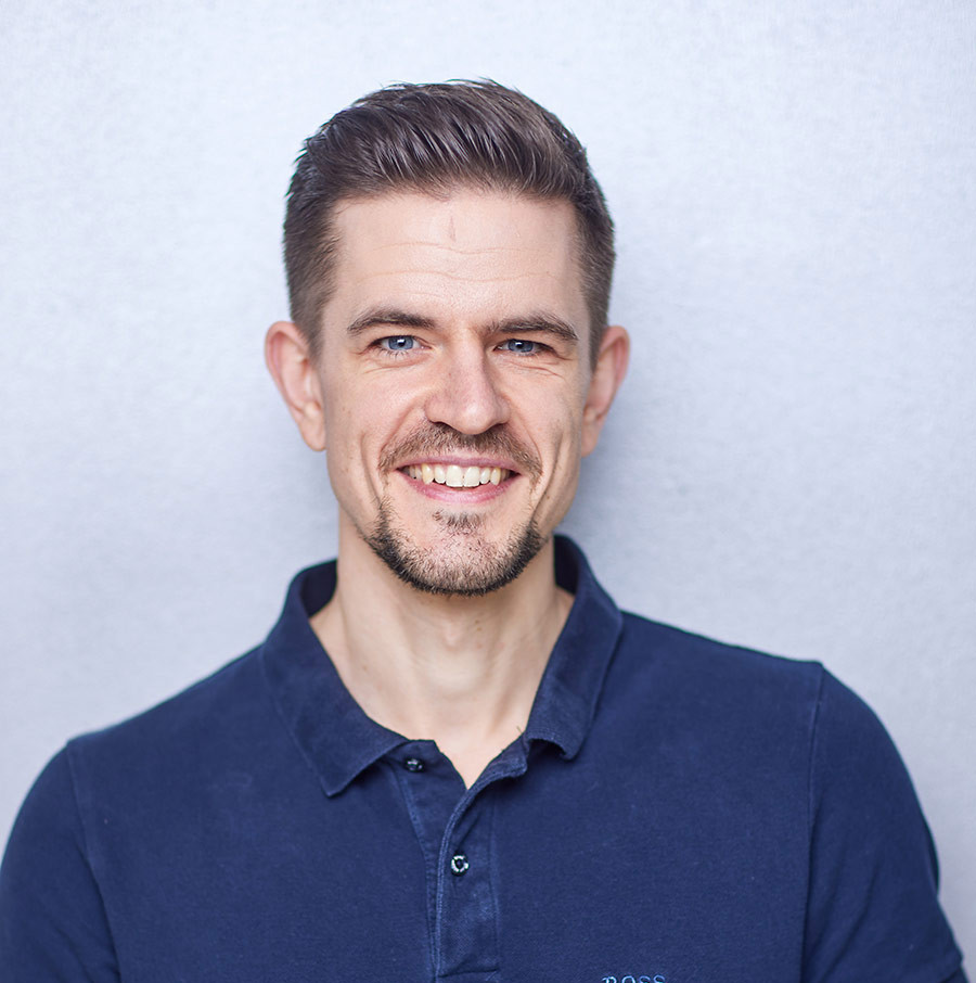 Portrait von Daniel Niehaus vor grauem Hintergrund