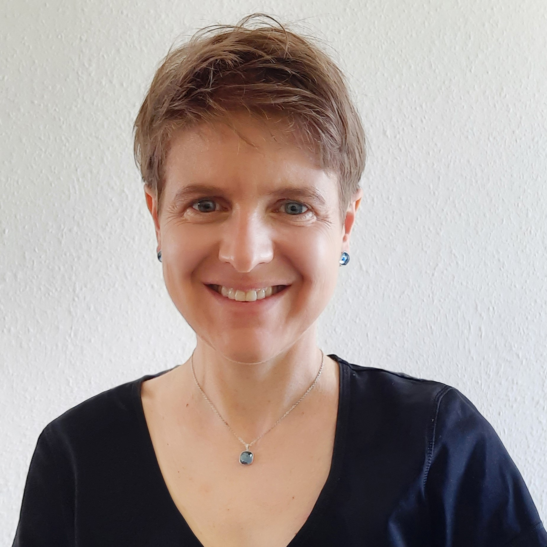 Porträtfoto von Dr. Sabine Nunius vor hellem Hintergrund