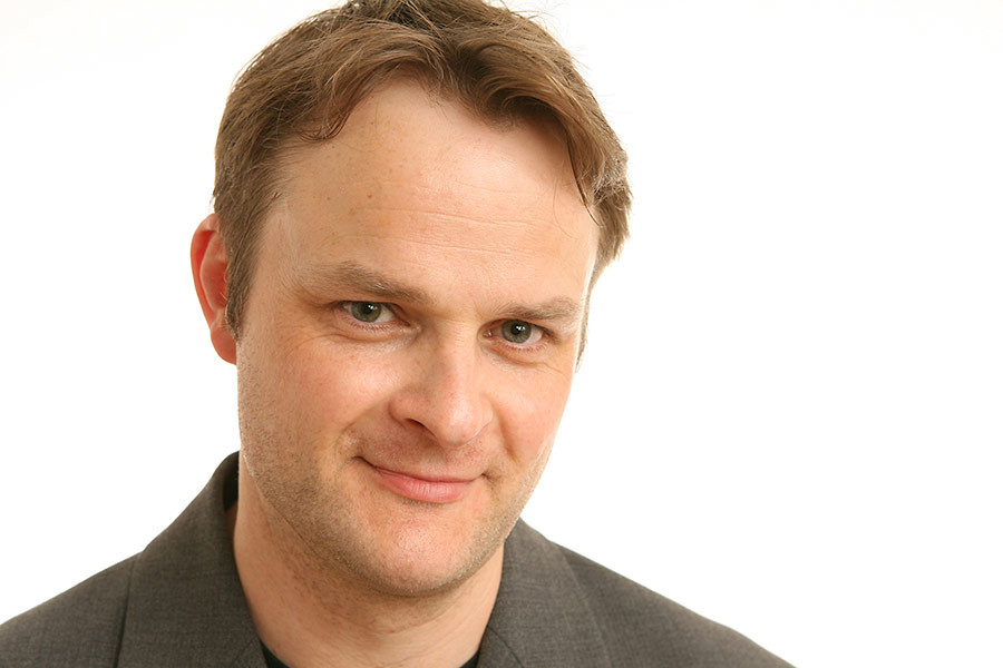 Portrait von Martin Quedenbaum mit Anzug vor weißem Hintergrund