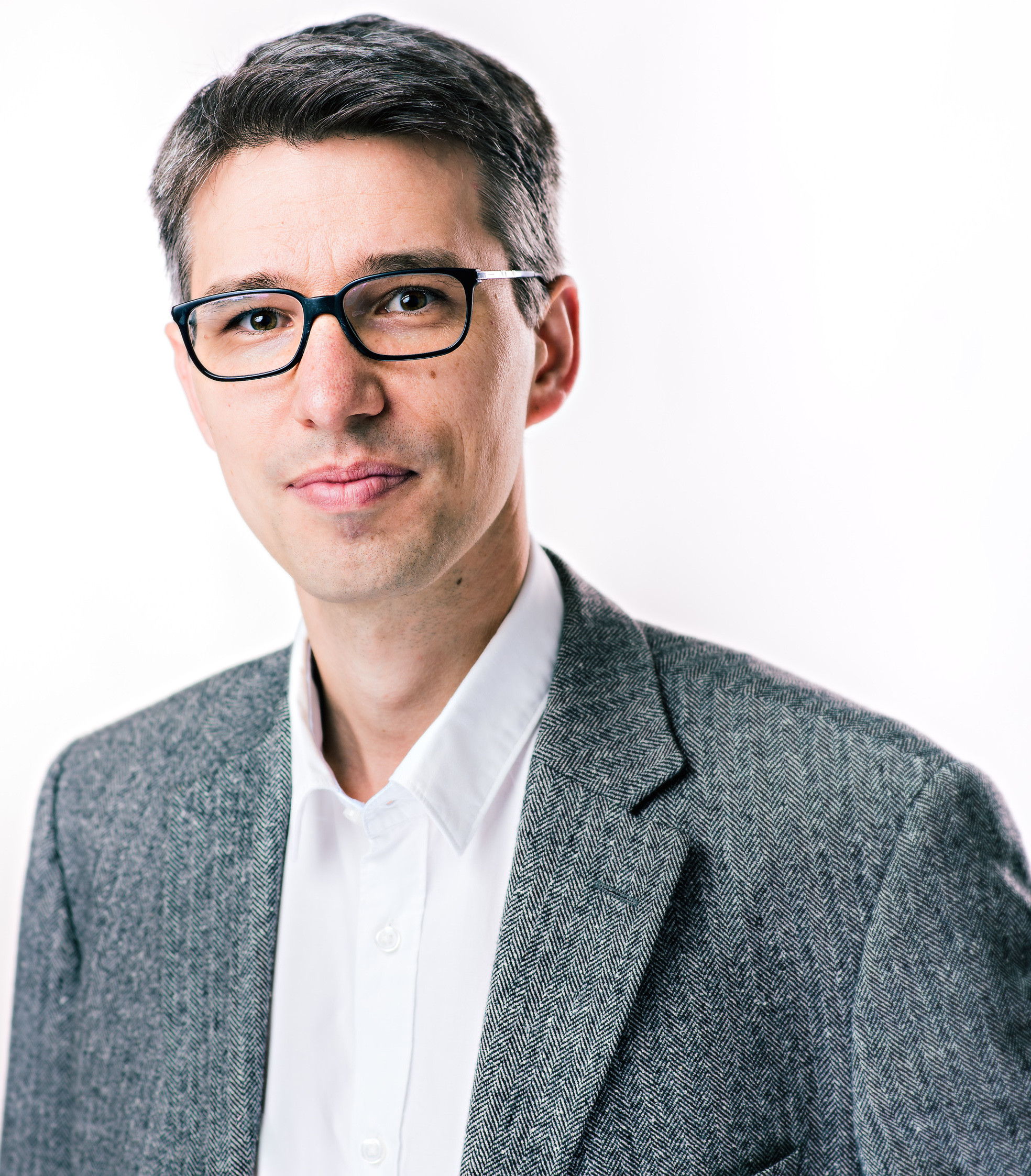 Portrait von Priv.-Doz. Dr. Stefan Riss im grauen Sakko und weißem Hemd
