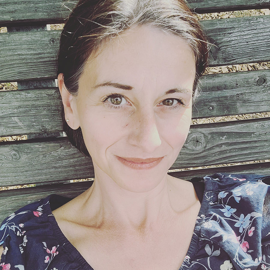 Porträt von Barbara Weber-Eisenmann auf einer Holzbank im Freien
