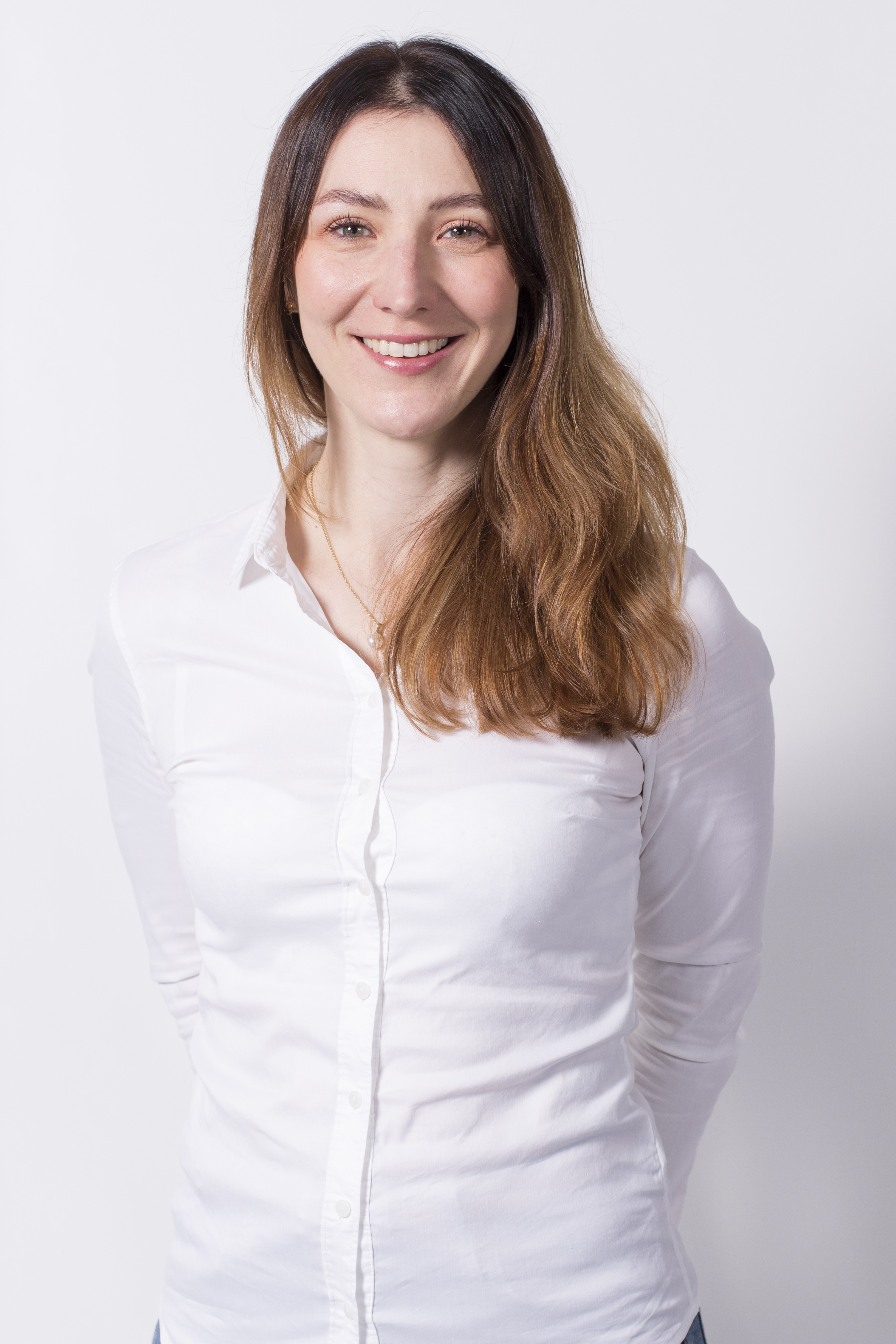 Portrait von Dr. med. Maria Zeising in weißer Bluse vor neutralem Hintergrund