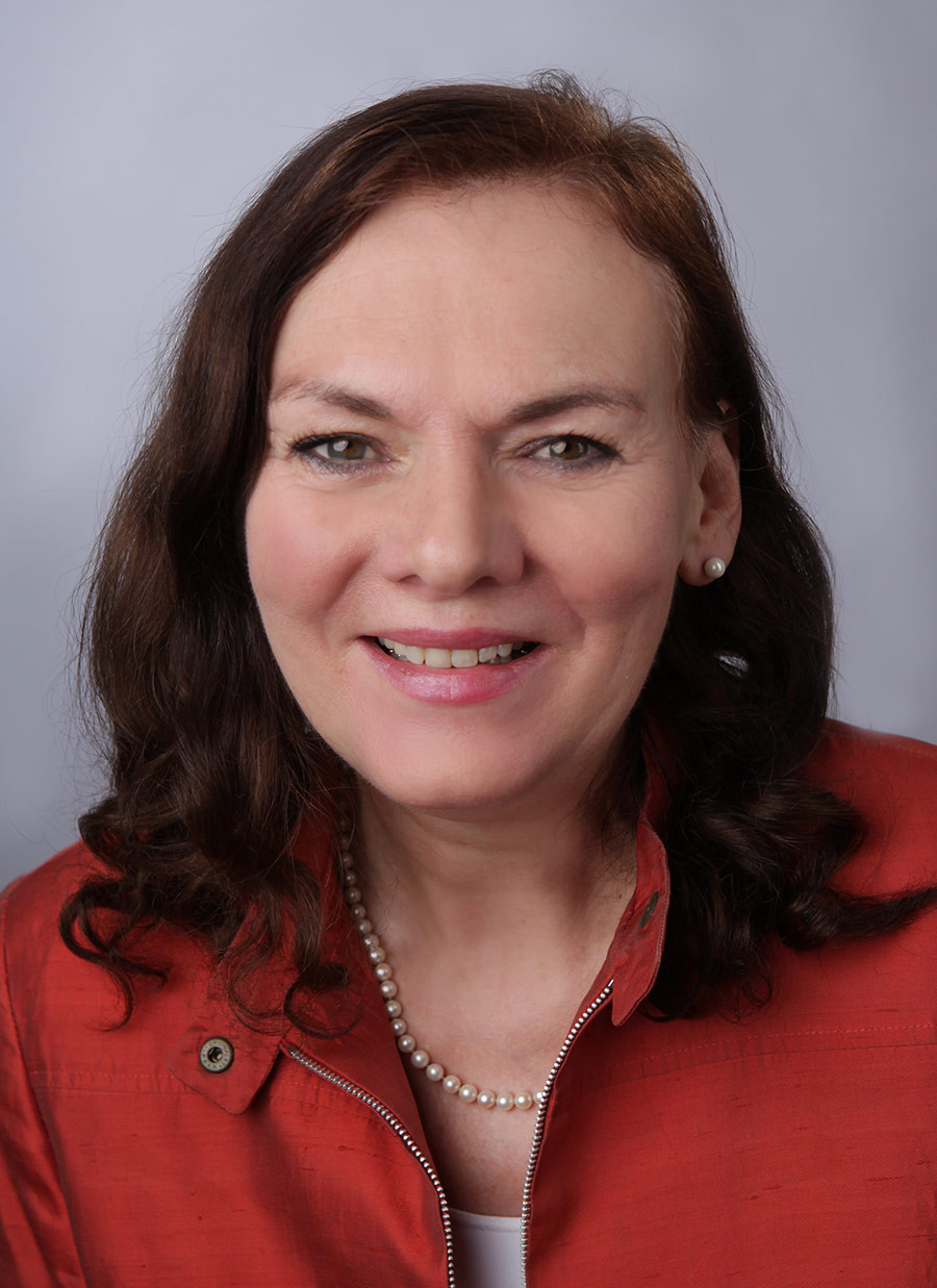 Portrait von Dr. med. Heike Buess-Kovacs mit roter Jacke und Perlenkette