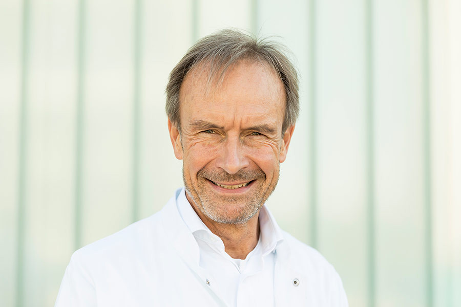 Porträt von Prof. Dr. Eike Sebastian Debus im weißen Arztkittel