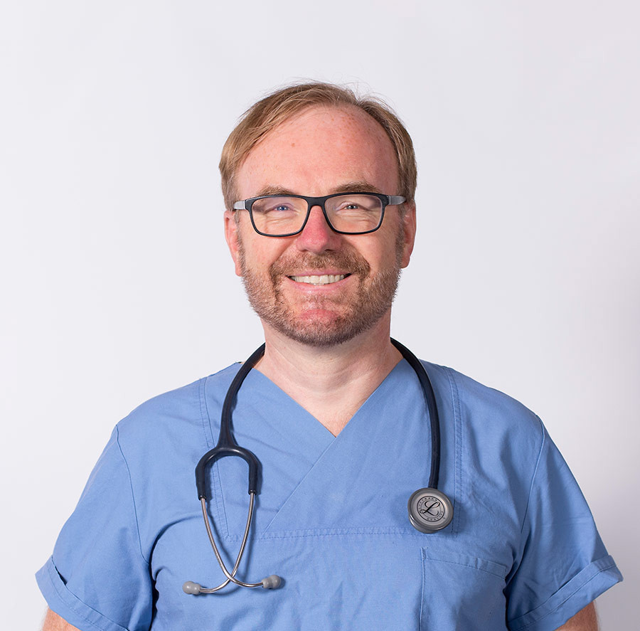 Porträt von Dr. med. Gerald Hofner in blauer Arztkleidung mit Stethoskop