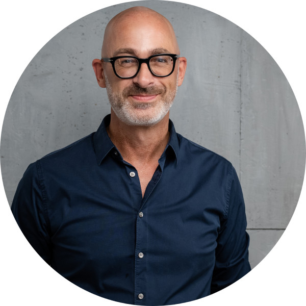 Porträt von Mark Wachsmann im Kreisformat vor grauem Hintergrund