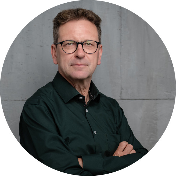 Porträt von Torsten Hilt im Kreisformat vor Betonwand