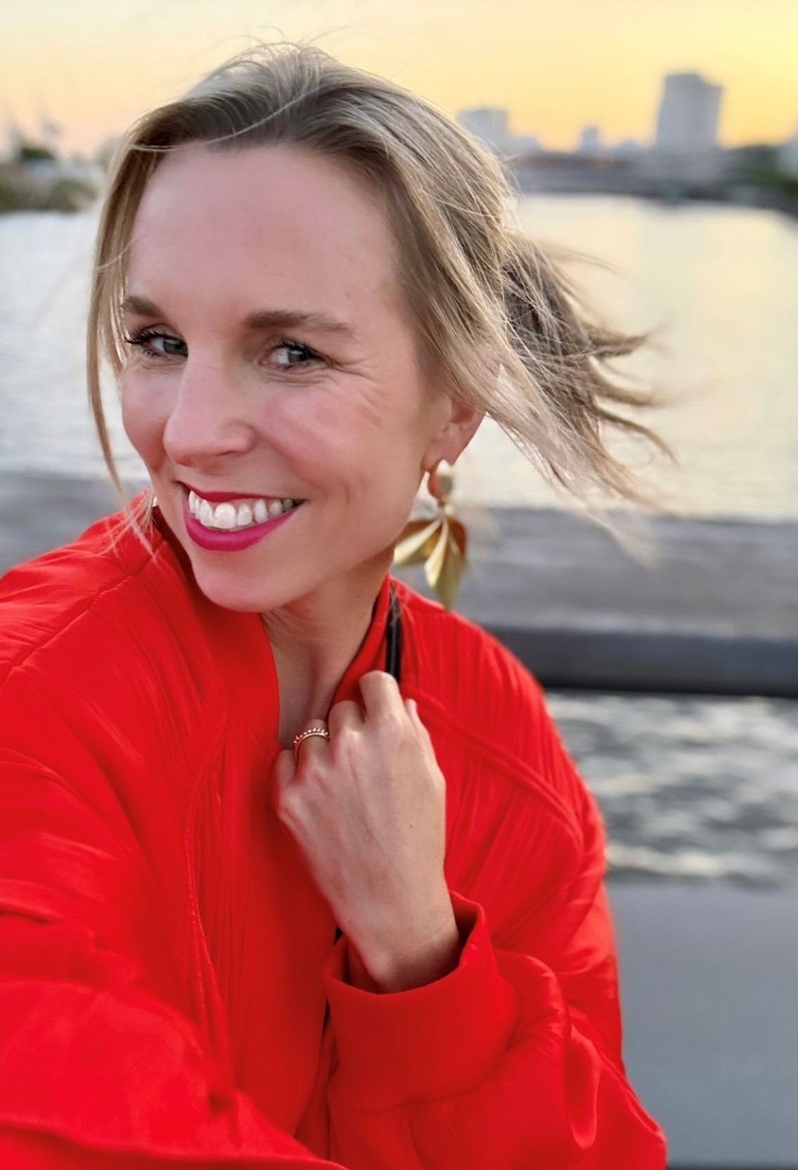 Porträt von Alena Mess im roten Outfit am Wasser