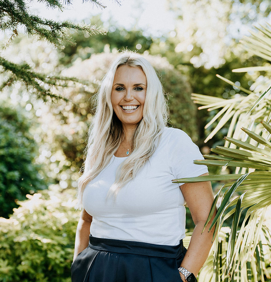 Caroline Strawson lächelnd im Garten, Porträtaufnahme