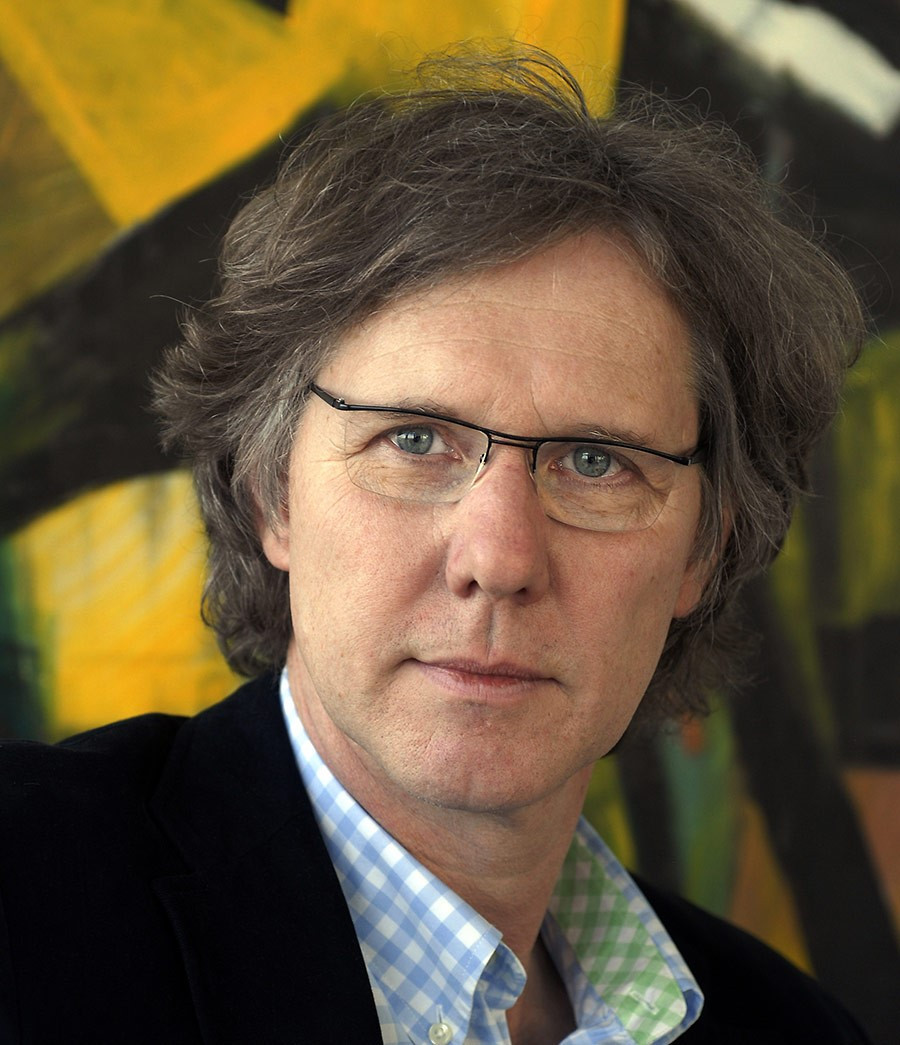 Porträt von Wolf Eberhard vor einem abstrakten Hintergrund