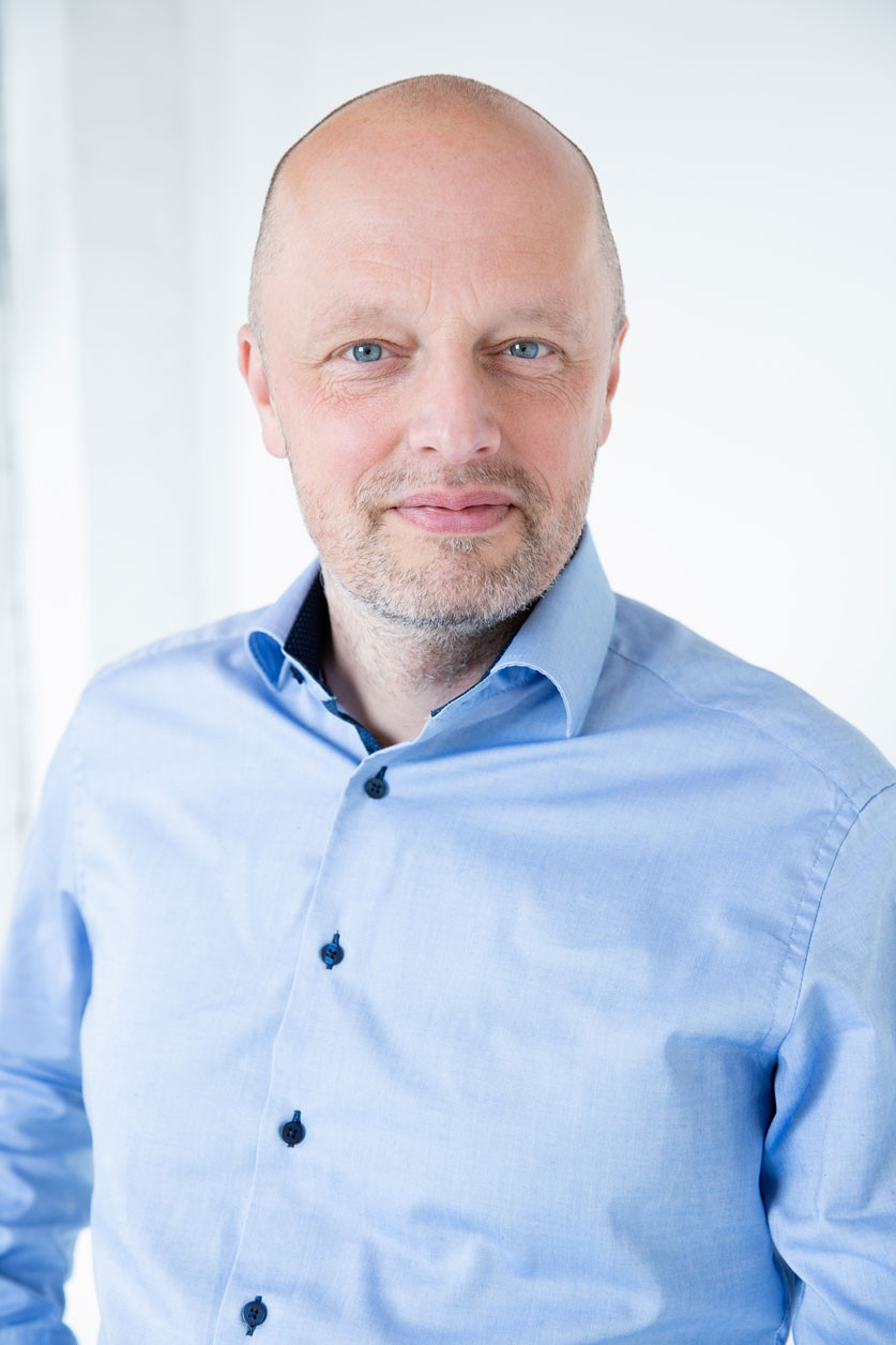 Portrait von Sascha Schmidt in einem hellblauen Hemd