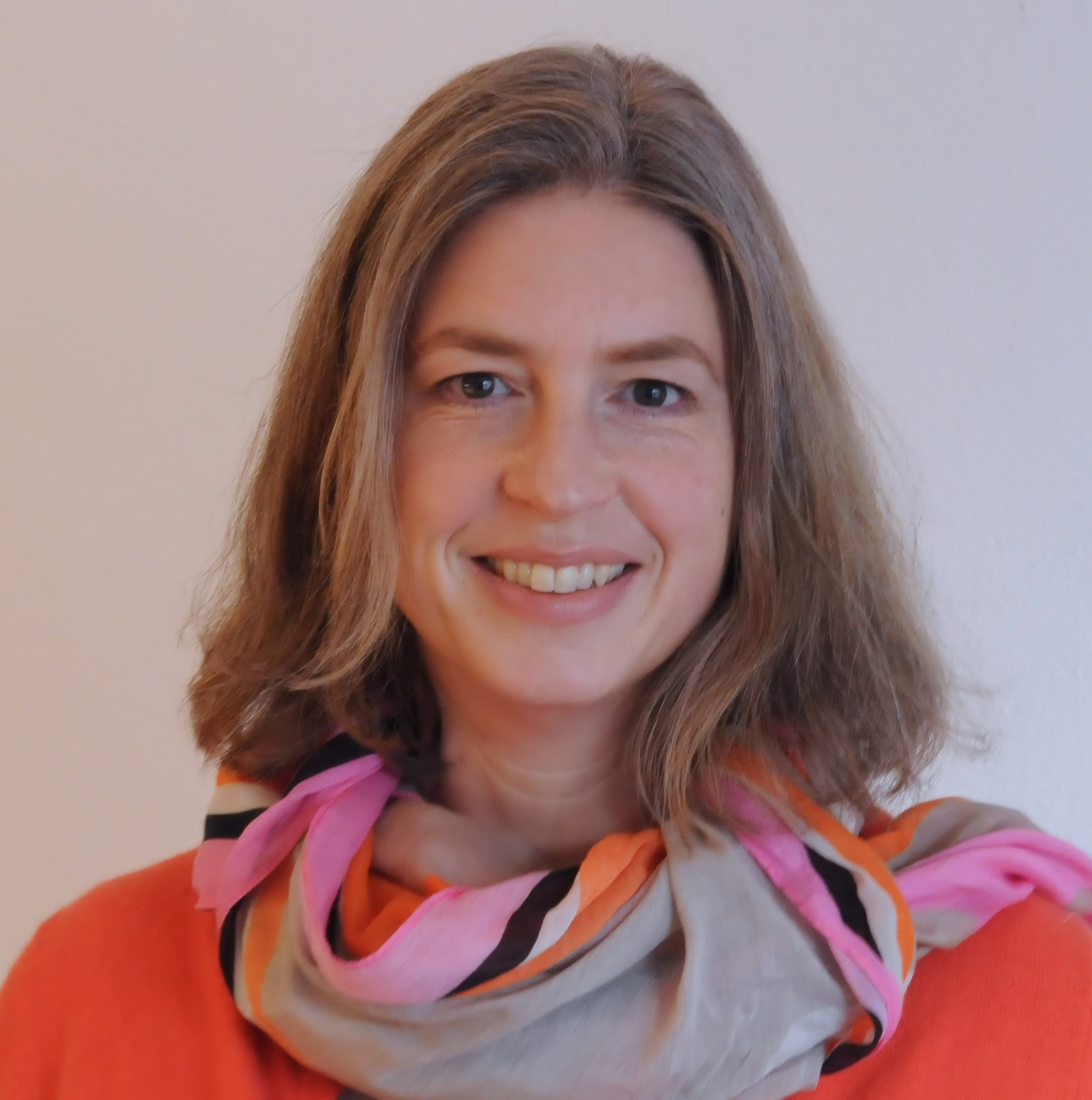 Portrait von Christiane Weissenberger mit buntem Schal und freundlichem Lächeln