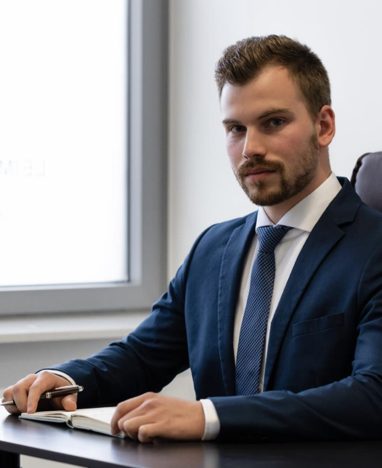 Lennart Büttner im Anzug am Schreibtisch, Business-Porträt