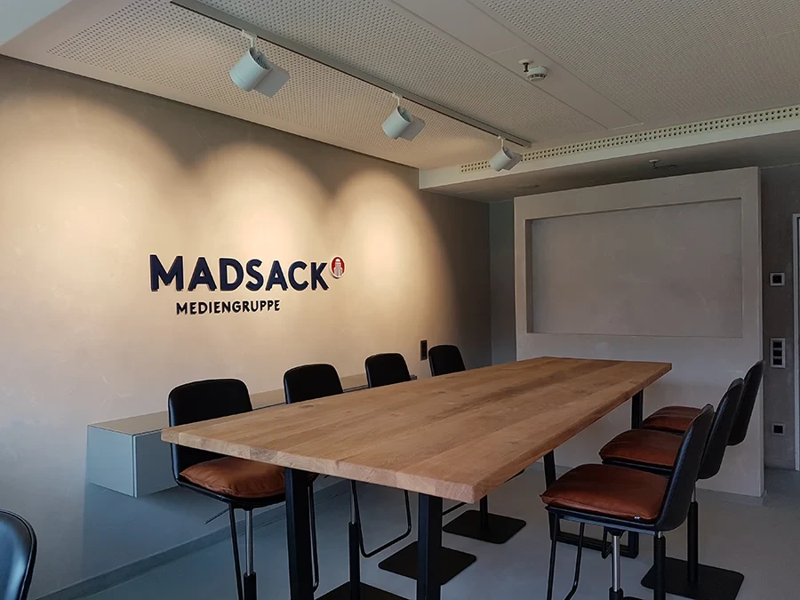 Moderner Konferenzraum der MADSACK Mediengruppe mit Holztisch und Stühlen als Referenz von Farbgestalt