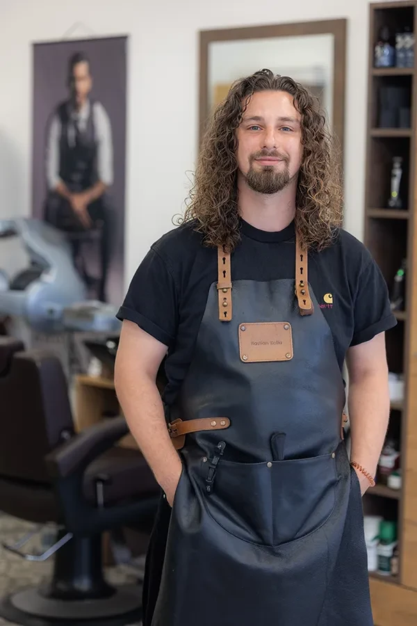 Bastian als Friseur mit Lederschürze im modernen Friseursalon