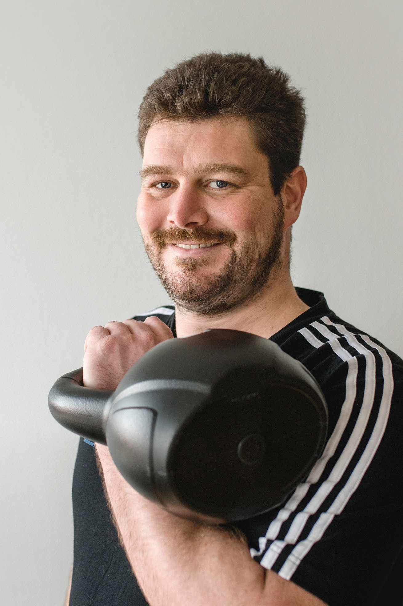 Mann trainiert mit Kettlebell im Hochformat, Sport und Fitness