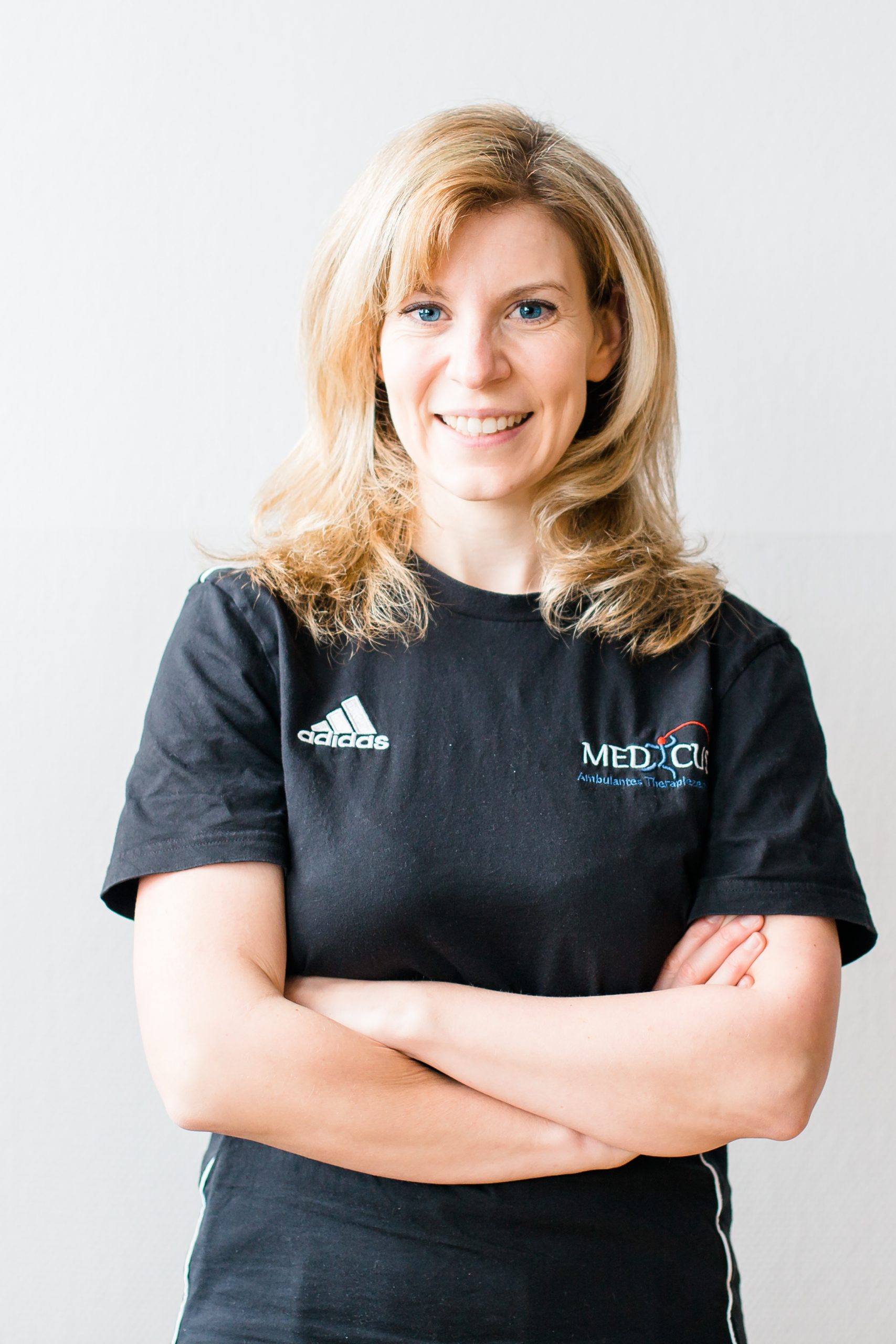 Porträt einer Frau mit MEDICUS Shirt und verschränkten Armen, liebeimblick-6-von-50-scaled