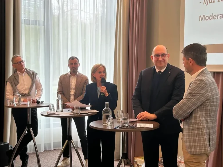 Verbandstag der Bäcker – Teilnehmer im Gespräch während einer Konferenz Diskussion beim Verbandstag der Bäcker mit mehreren Teilnehmern an Stehtischen in einem Konferenzraum.