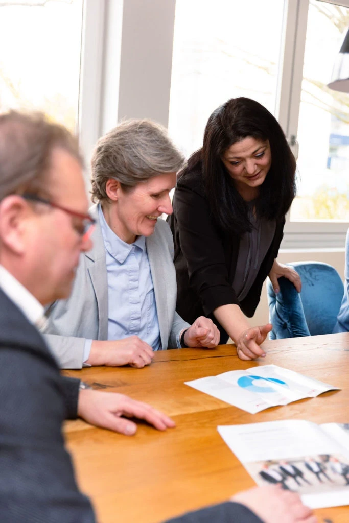 Besprechung der Werbemittel in einem modernen Büro mit mehreren Personen am Tisch