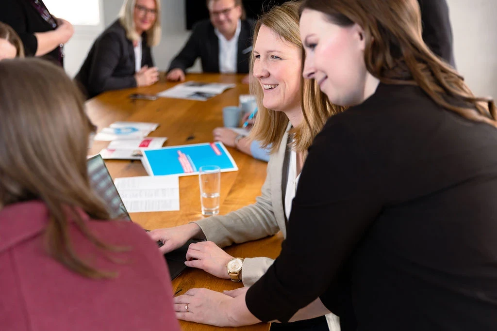 Großes Teammeeting mit mehreren Personen am Konferenztisch, konzentriert bei der Teamarbeit.