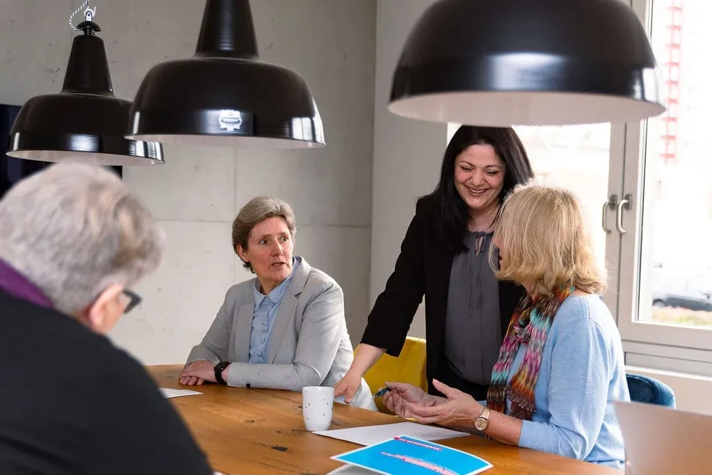 Großes Teammeeting mit mehreren Personen an einem Konferenztisch
