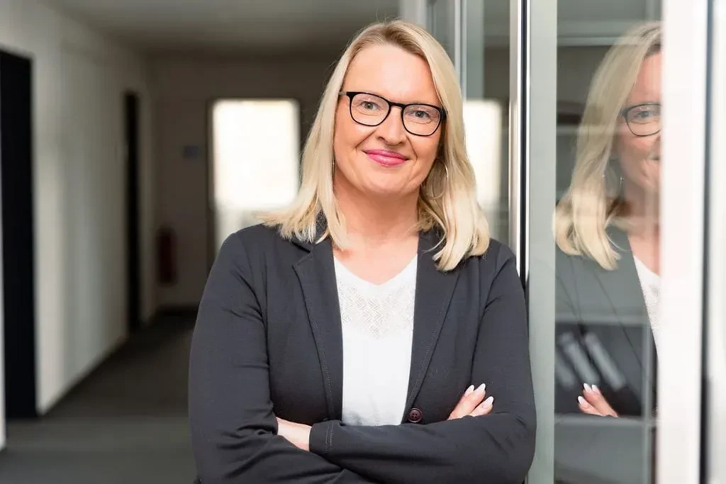 Porträt von Sina Valerius, Businessfrau mit Brille und blondem Haar im Büro