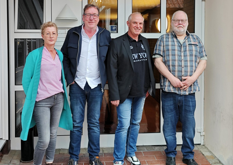 Neuer Vorstand der Friseure im Mai 2026 – Gruppenfoto vor dem Eingang Neuer Vorstand der Friseure im Mai 2026 vor einem Gebäude
