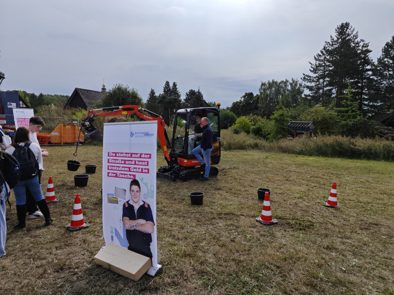 Bau-Event mit Minibagger und Baugewerbeverband Niederbayern Bau-Event mit Minibagger und Werbebanner des Baugewerbeverbands Niederbayern auf einer Wiese
